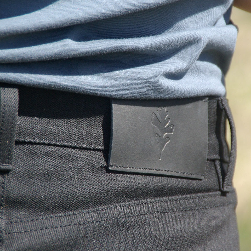 Black Selvedge Denim and Detailed view of Deer hunted leather patch with Ginew Genesis Oak Leaf on model.
