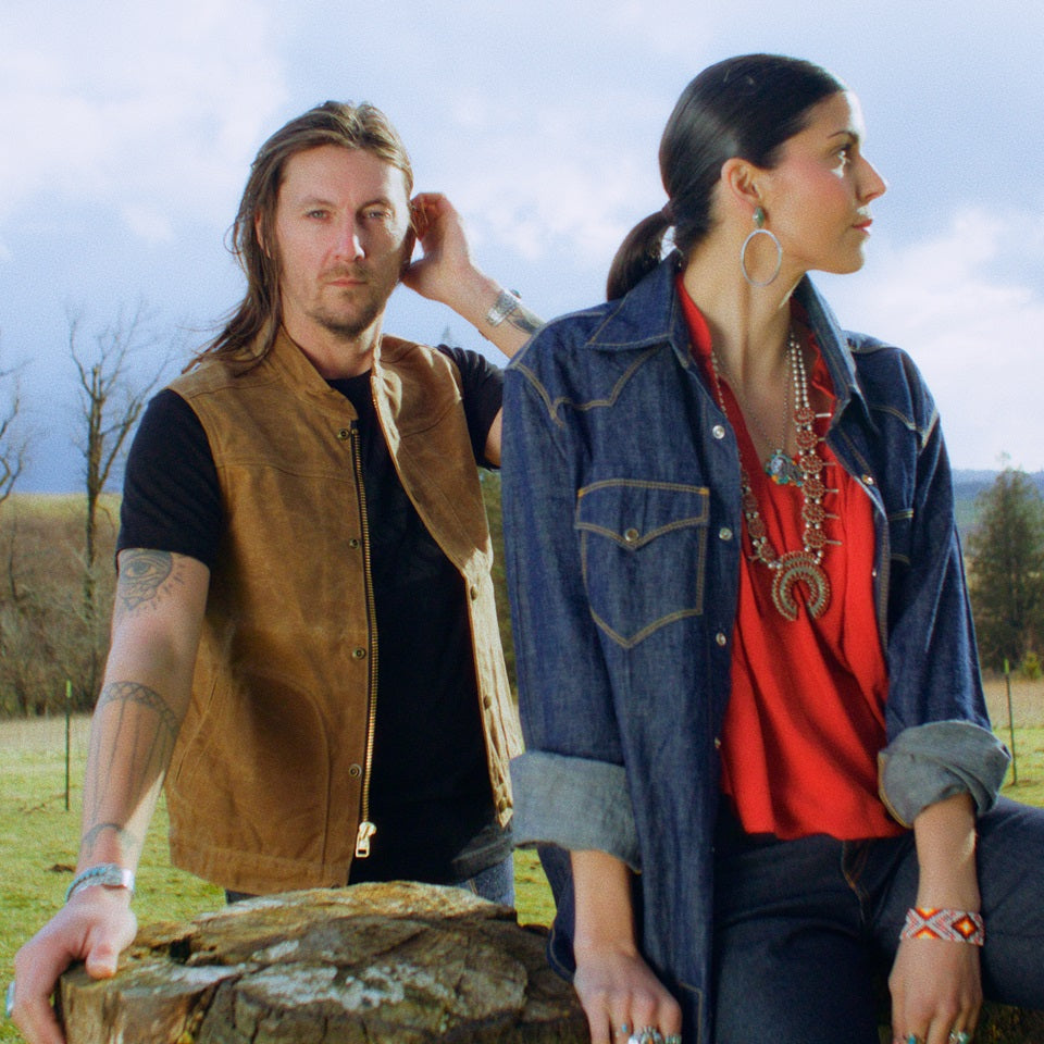 Chambray western shirt with red ruffle shirt on Native American model and wax canvas vest with black tshirt on male model