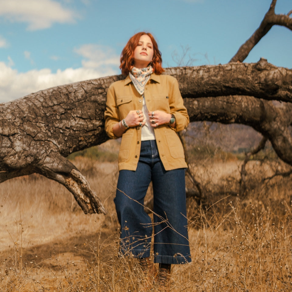 Woman in tan saddle barn chore jacket in field