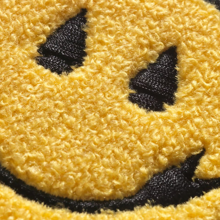 Close up of Chenille smiley face sew on patch designed by Native American Steven Paul Judd with arrowhead smile and eyes.