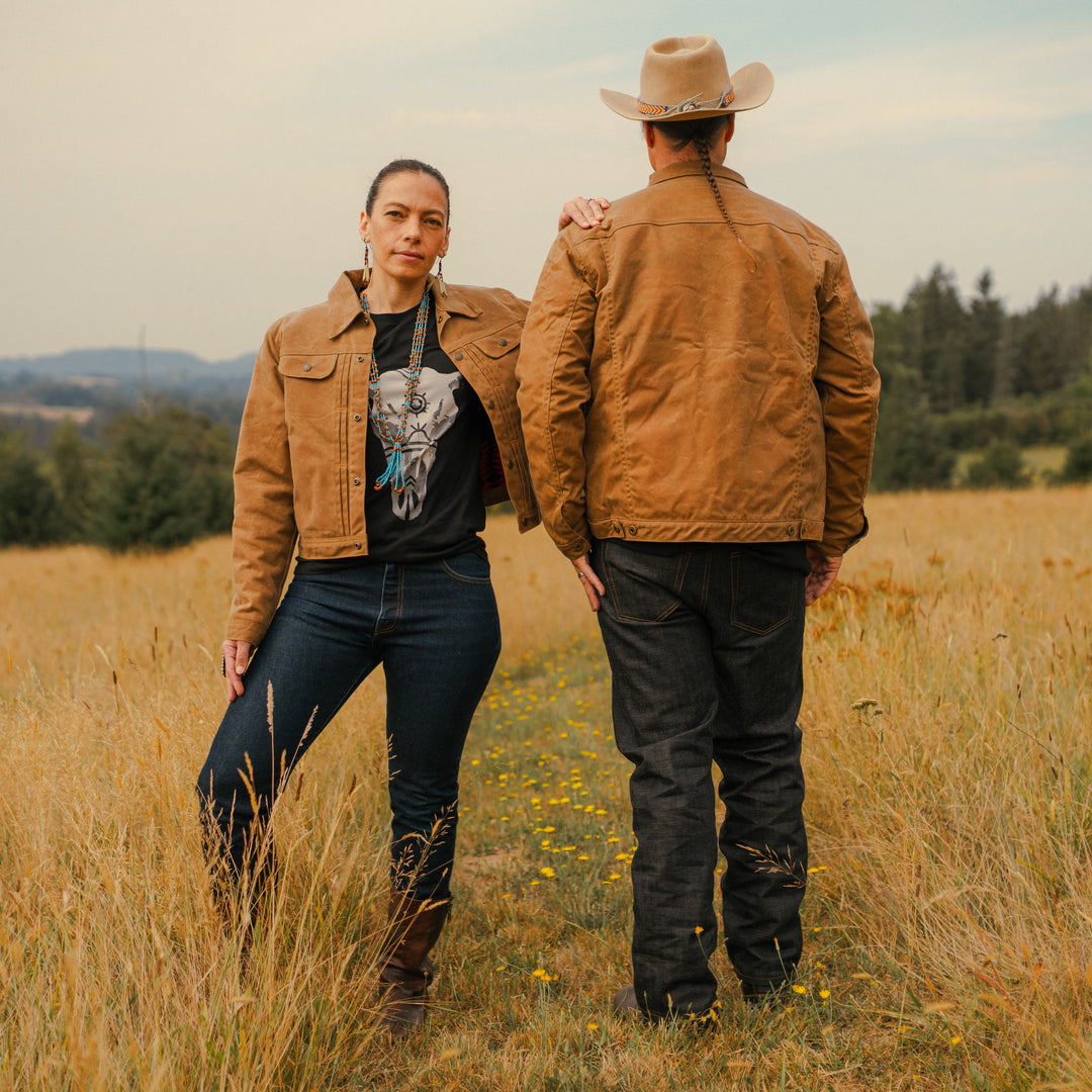 Native American man and women in brown wax canvas coat in field