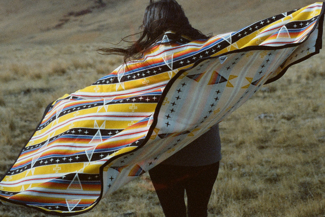 Native American model wearing yellow wax canvas hat in field