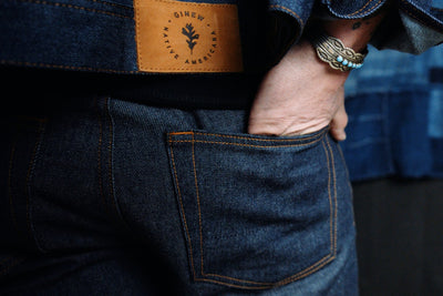 Ginew Selvedge Denim Jeans close up and denim jacket worn by Native American model walking in forest.
