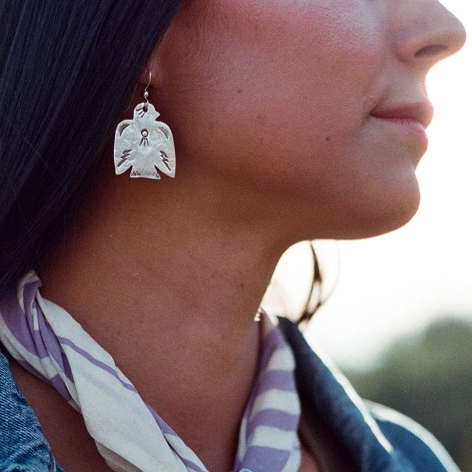 Native American designed sterling earring jewelry on model with white and purple bandana