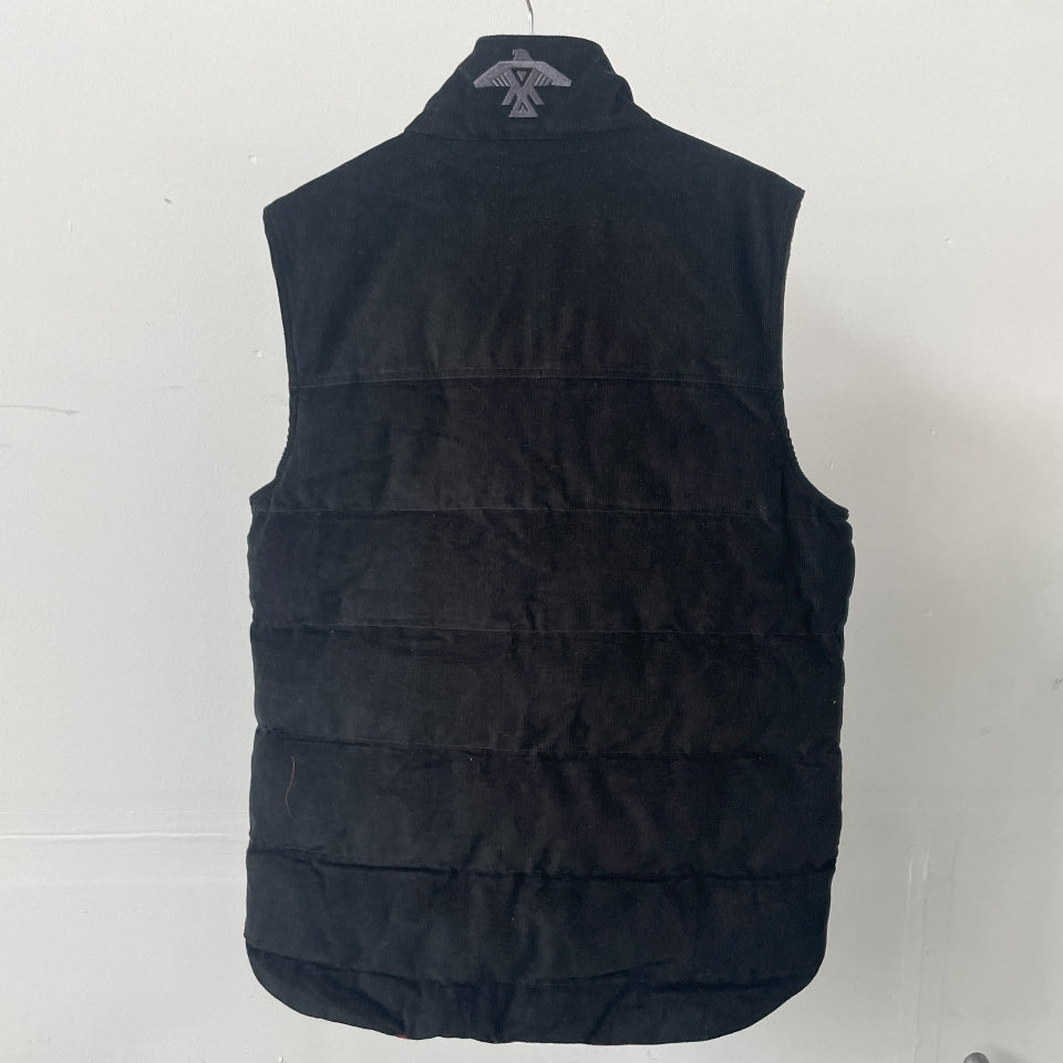 Black puffer vest on a white background