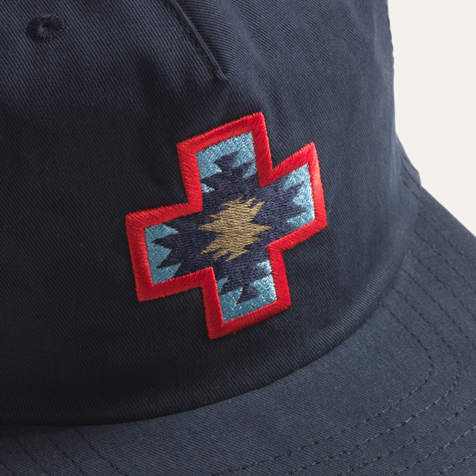Close up of Navy snap back hat made by Ginew with Native American 4 Direction embroidery 