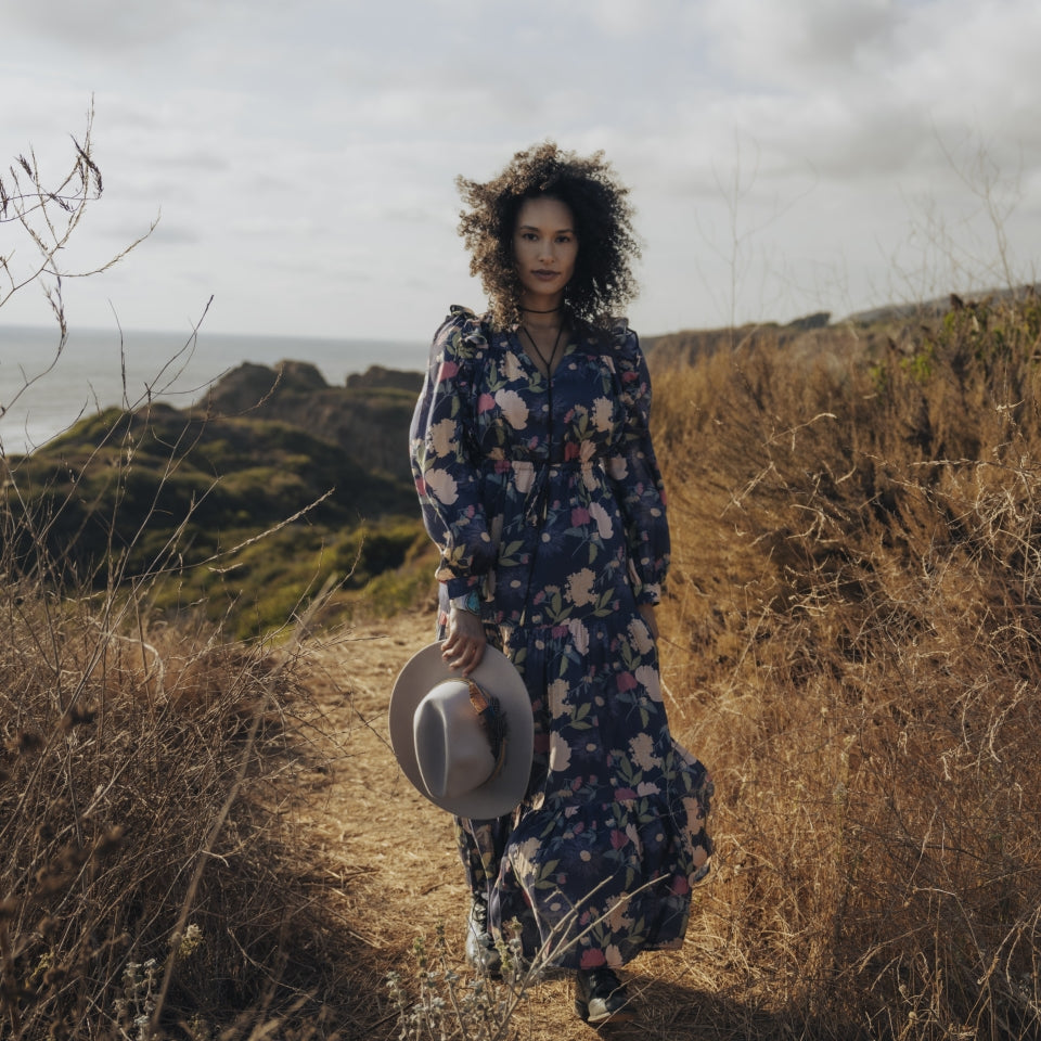 Front length of Raw Silk Dress with sophisticated flower print and side ruffles on women at ocean hillside