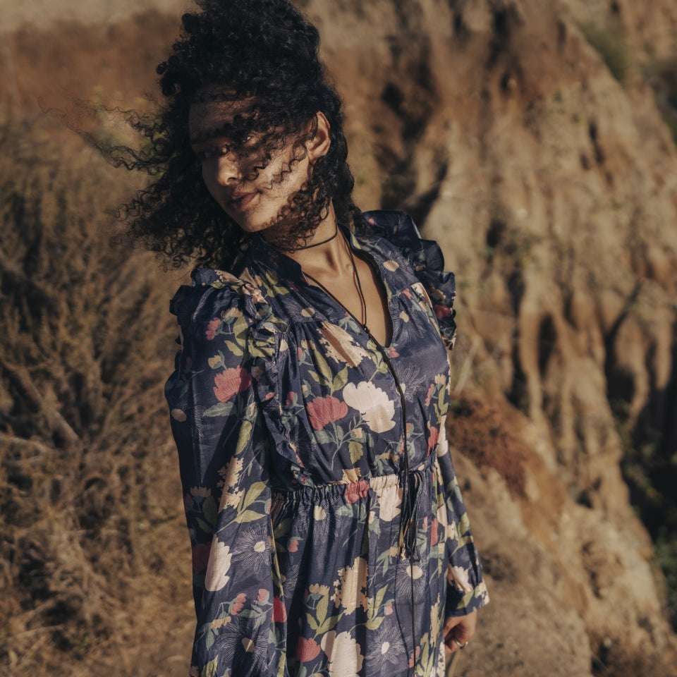 Close up of top of Raw Silk Dress with sophisticated flower print and side ruffles on women at ocean hillside