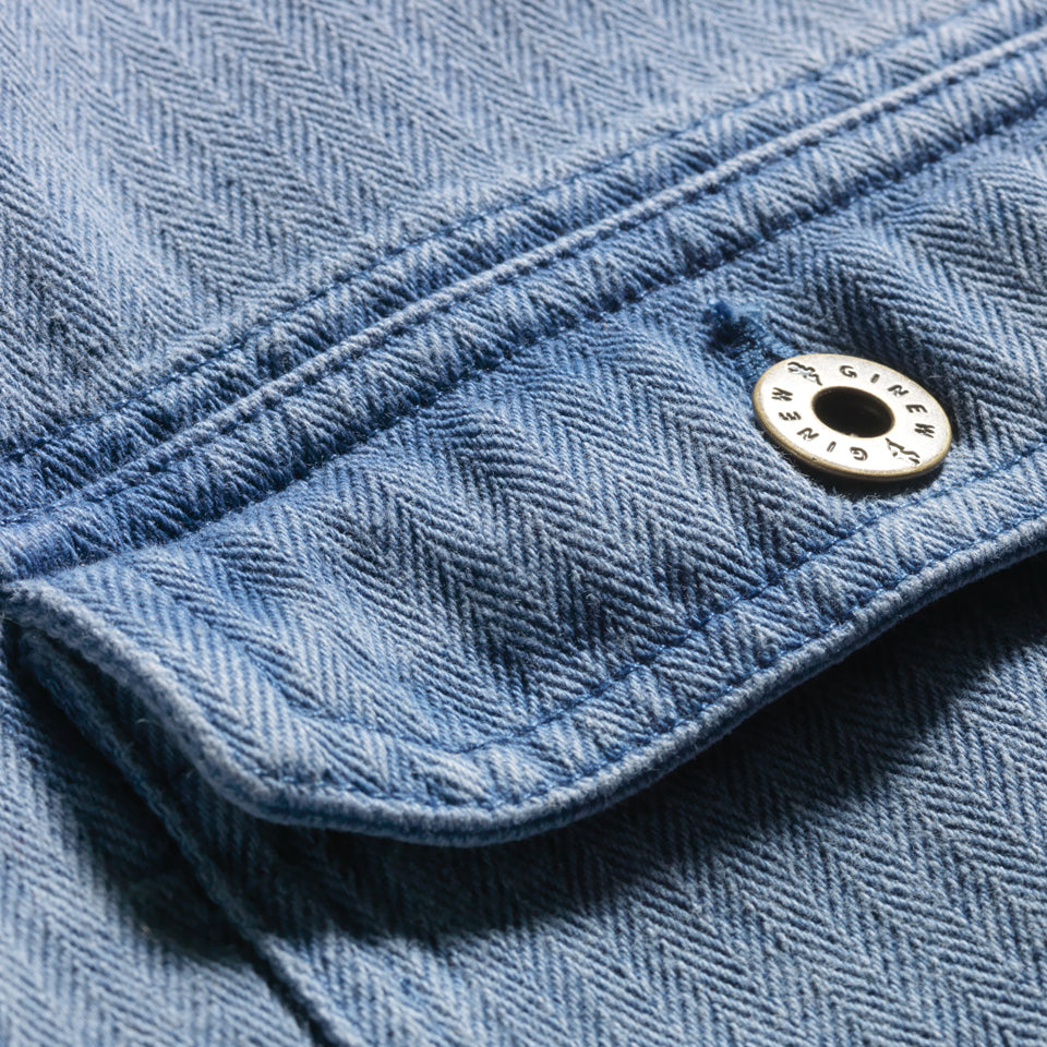 Close up of button pocket on Indigo blue cotton barn jacket male and female all gender with four pockets