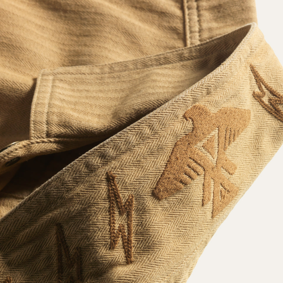 Thunderbird embroidery on collar of tan saddle color cotton barn jacket male and female all gender with four pockets