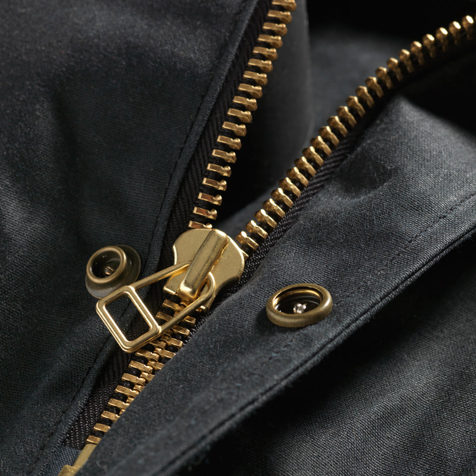 Close up of brass hardware on Made in USA black wax canvas vest by Native American Ginew