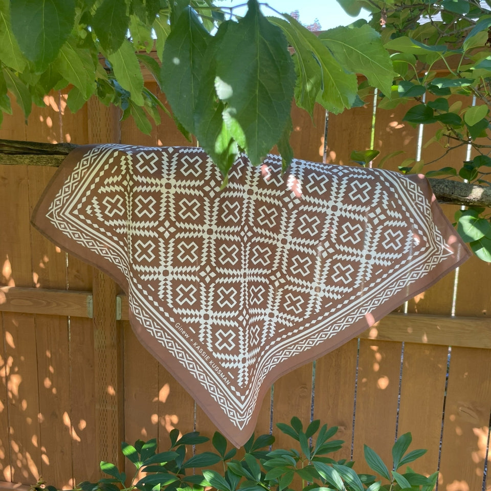 Hanging on branch Native American Indigenous Artist designed cotton bandana in brown and natural white 