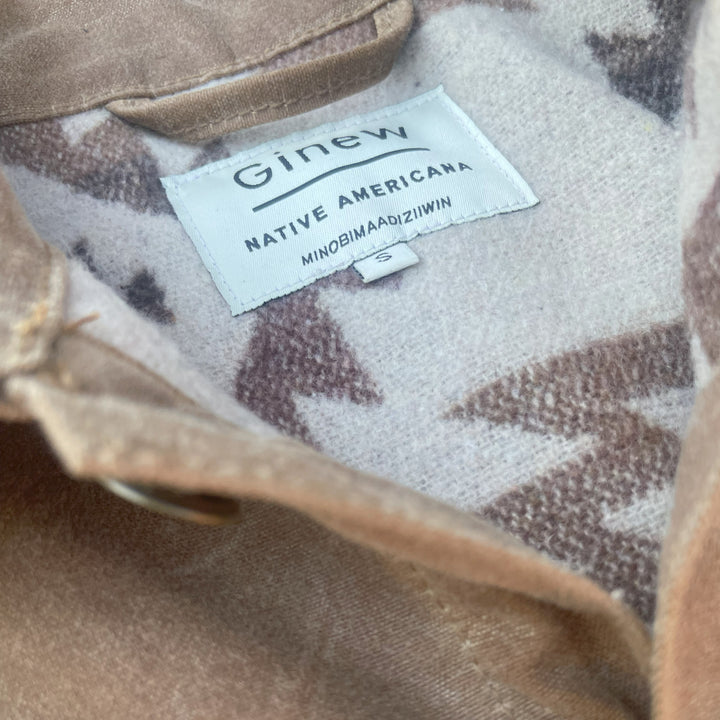 Tag on Brown wax canvas rider coat lined in Native American brown and cream wool made by Indigenous owned Ginew