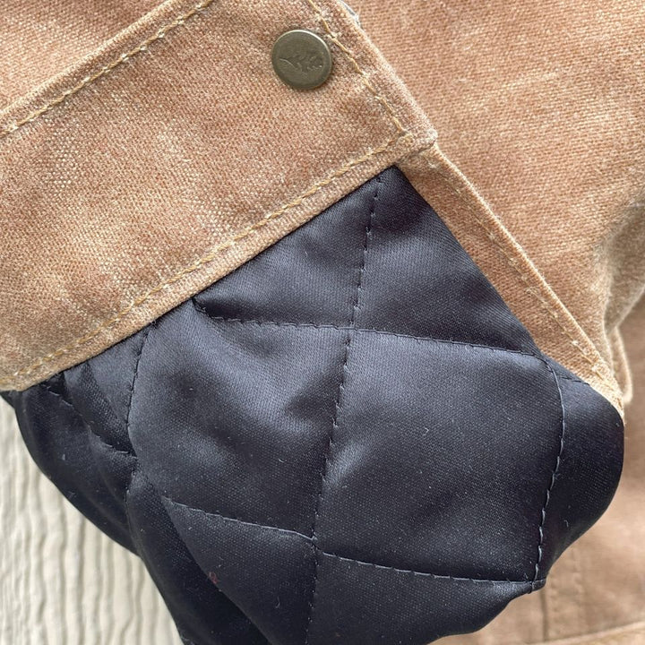Quilted arms of Brown wax canvas order coat lined in Native American brown and cream wool made by Indigenous owned Ginew