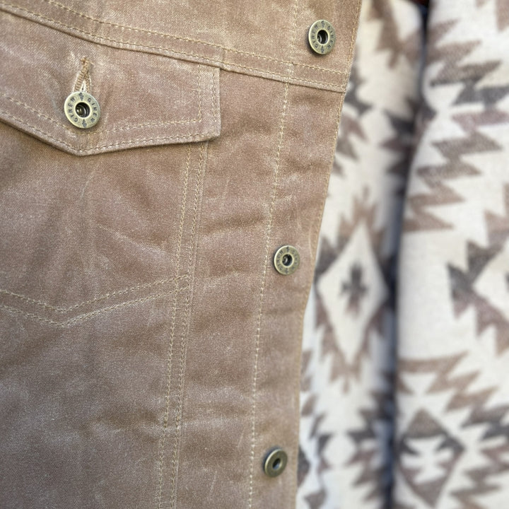 Front pocket of Brown wax canvas rider coat lined in Native American brown and cream wool made by Indigenous owned Ginew