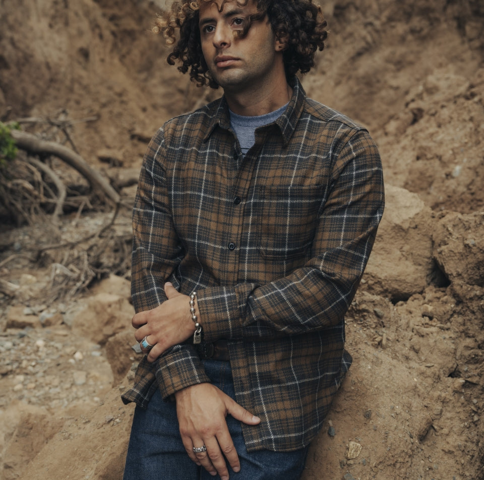 Man wearing brown plaid wool shirt in canyon