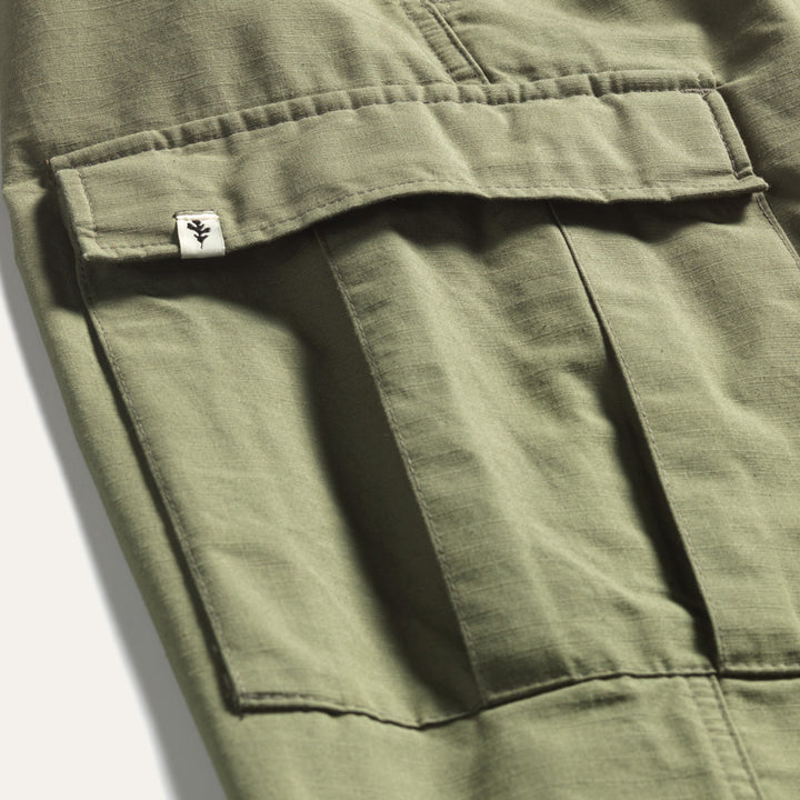 Green ripstop cotton cargos with close up of Genesis Leaf Tag on Side Pocket.
