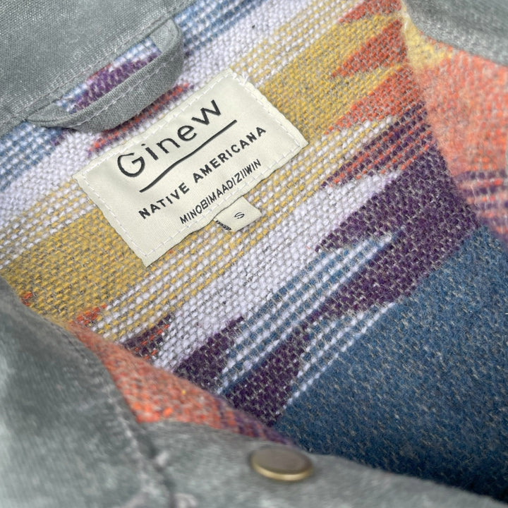 Tag on Gray silver charcoal wool lined coat with a colorful Native American patterned lining by Ginew