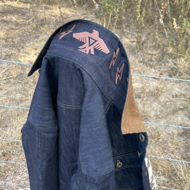 Close up on embroidery on Indigo Denim Chore Barn Field oat with wool lining and Native American Thunderbird 