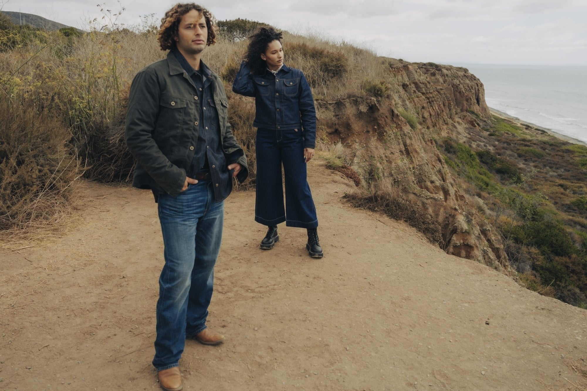 Ginew Wax Canvas lined coat and deadstock denim jean jacket on couple at beach