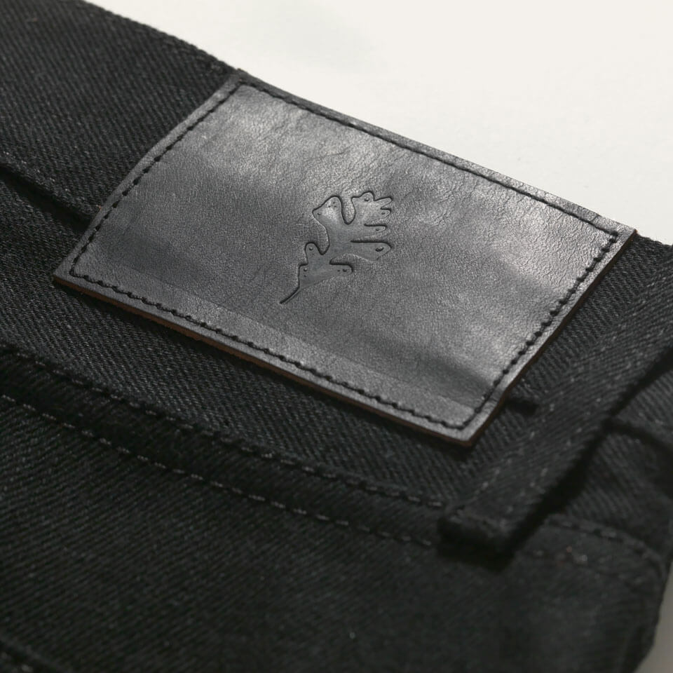 Black selvedge denim jeans made in USA. Detailed view of Deer hunted leather patch with Ginew Genesis Oak Leaf.