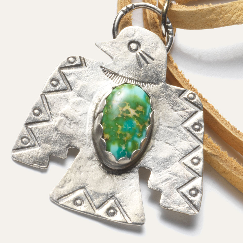 Silver Native American Thunderbird Necklace with turquoise middle and leather cord.