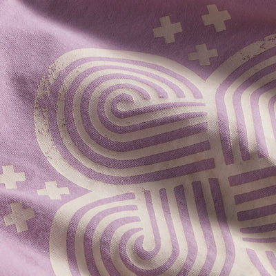 Close up of 4-Directions Knot graphic printed in white ink on a light purple shirt.