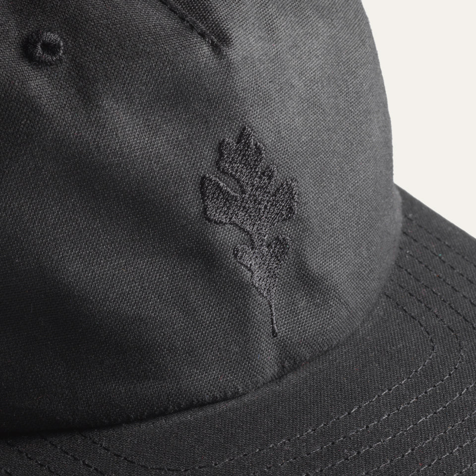 Close up of embroidered Genesis oak leaf on Ginew black wax canvas hat made in USA with Genesis Oak Leaf at center