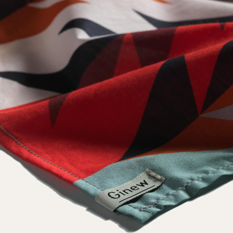 Close up of Colorful wild rag bandana in teal, red, and black all cotton with Ginew tag 