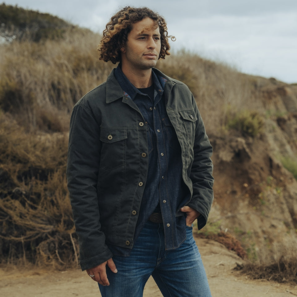 Male model wearing Green Herringbone coat lined in wool-blend at beach