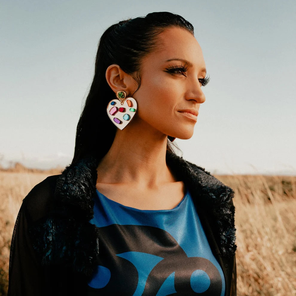 Indigenous woman wearing Gold plated stainless steal heart earrings made by Native American women