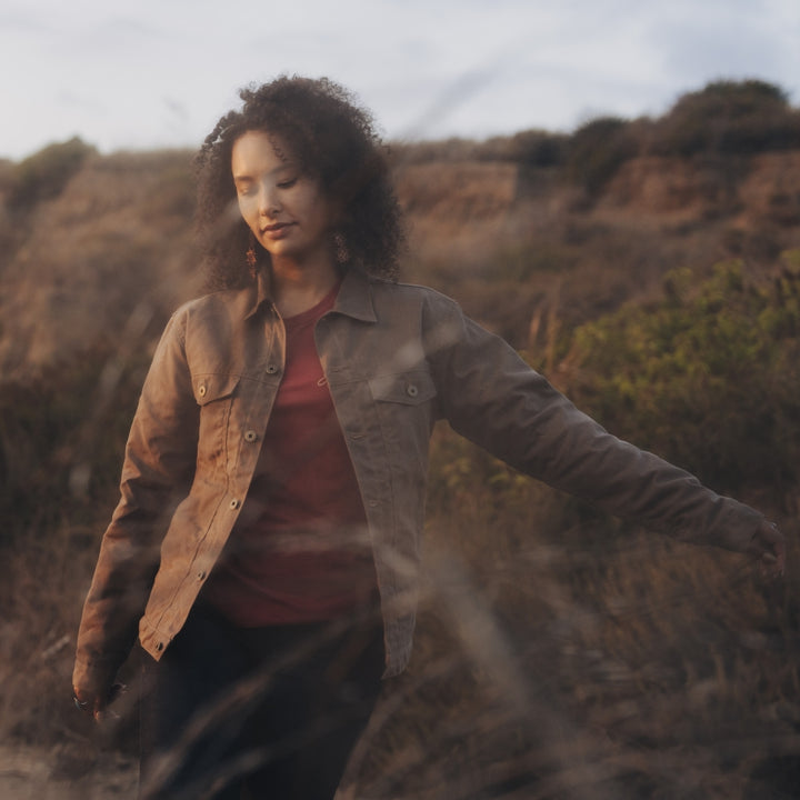 Woman wearing brown lined herringbone weave lined coat in field