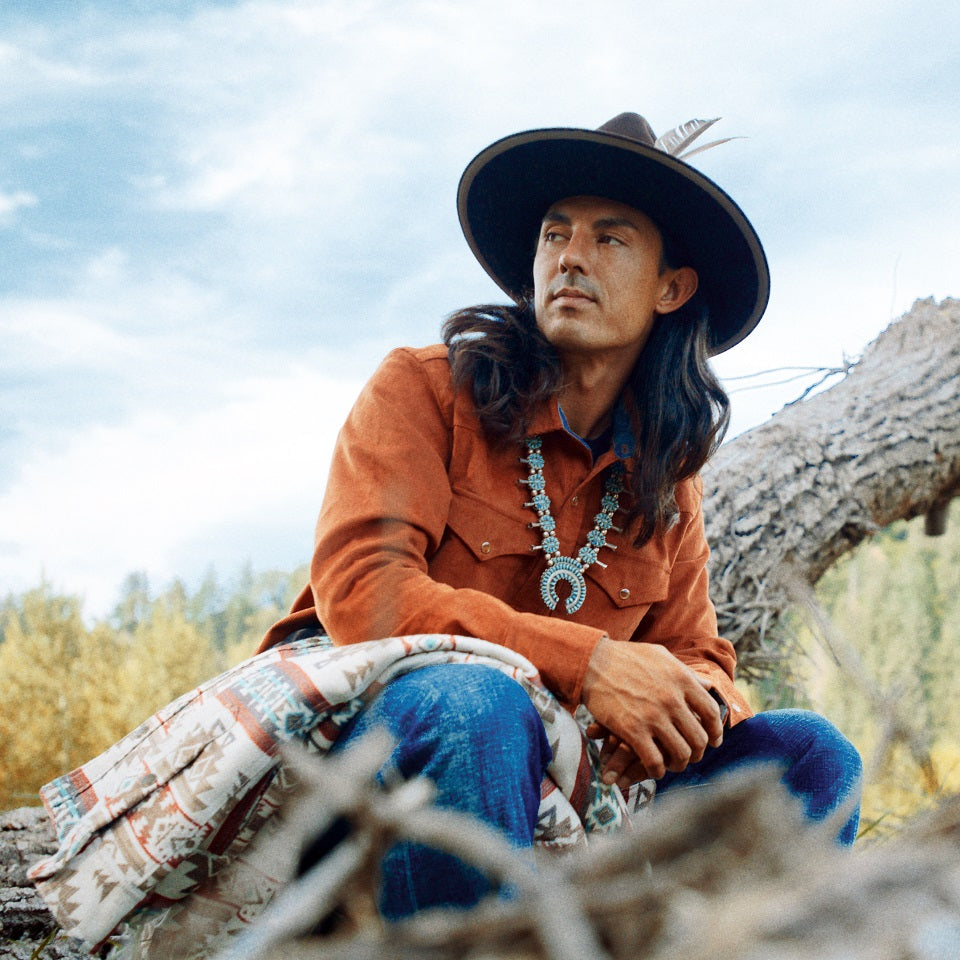 Native American wearing burnt orange corduroy shirt and selvedge denim jeans made in USA