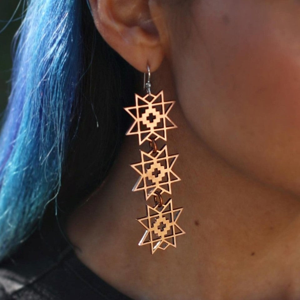 Native artist Kassie Kussman wearing copper star stacked handmade earrings