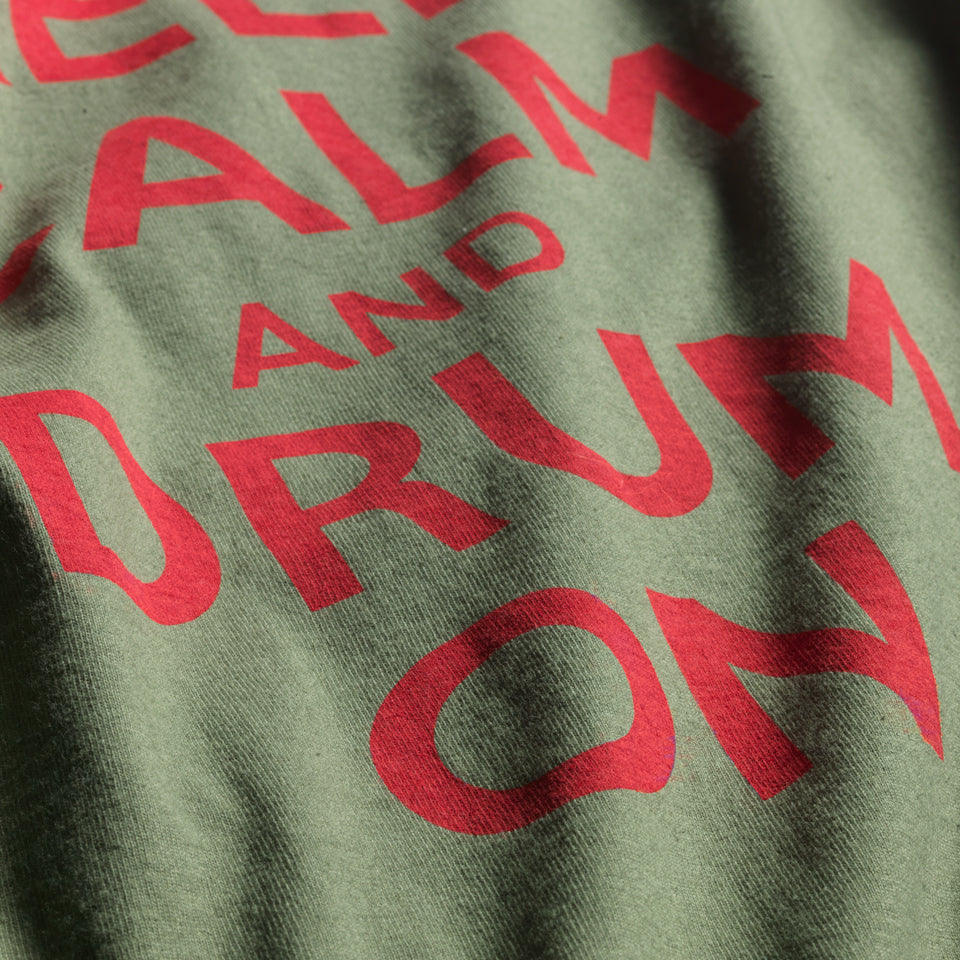 Close up of Green and red 100% all cotton t-shirt designed by Native American Ginew with keep calm and carry on text 