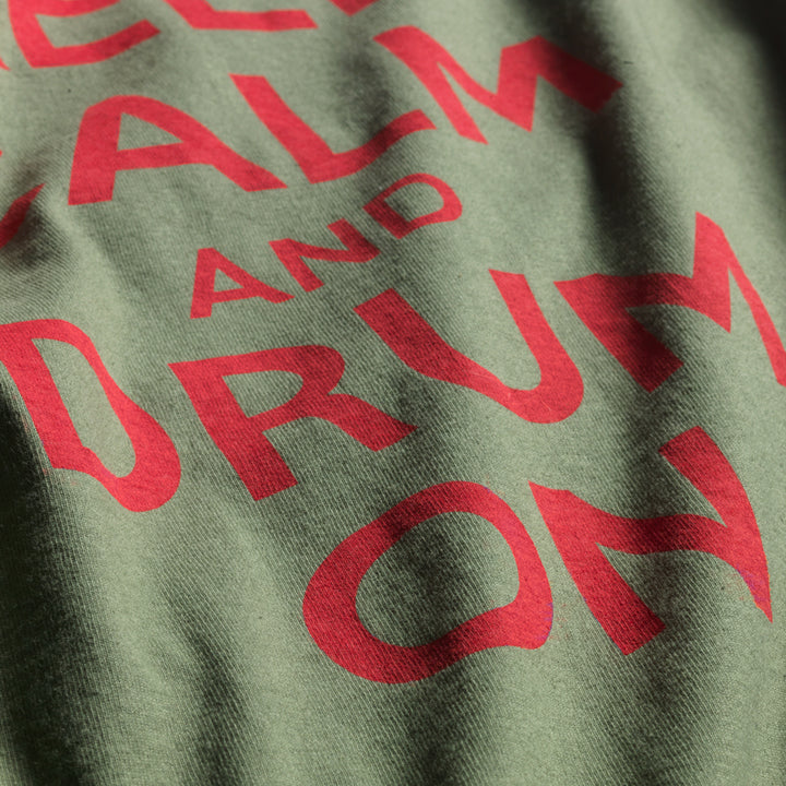 Close up of Green and red 100% all cotton t-shirt designed by Native American Ginew with keep calm and carry on text 