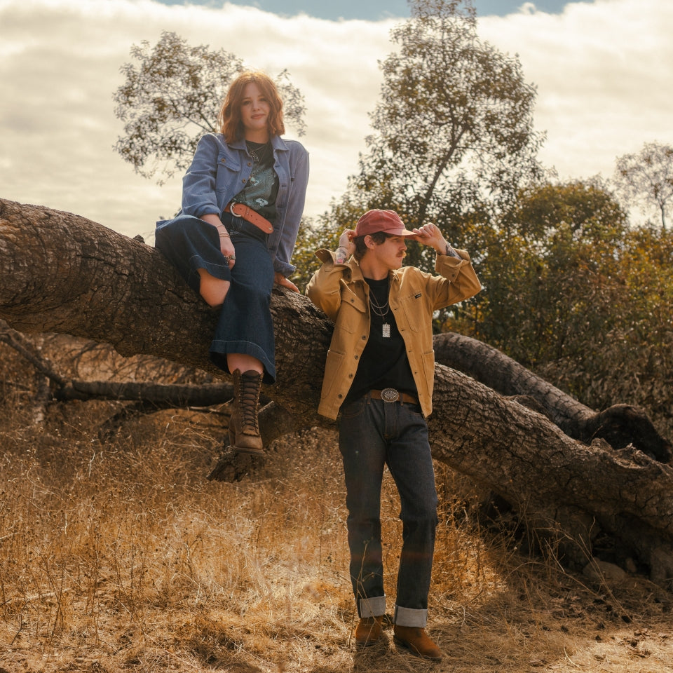 Blue indigo and tan saddle barn jackets on couple in nature