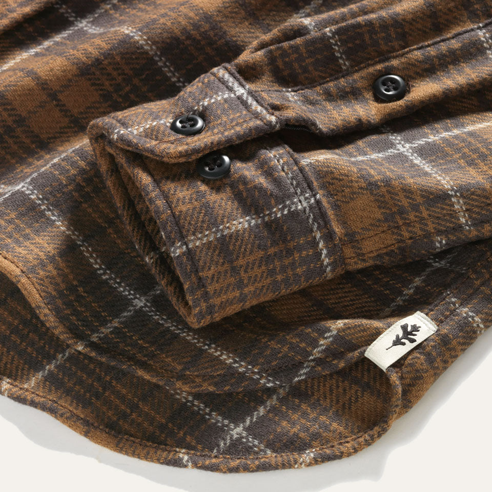 Cuff close up on brown plaid wool shirt with oak leaf tag