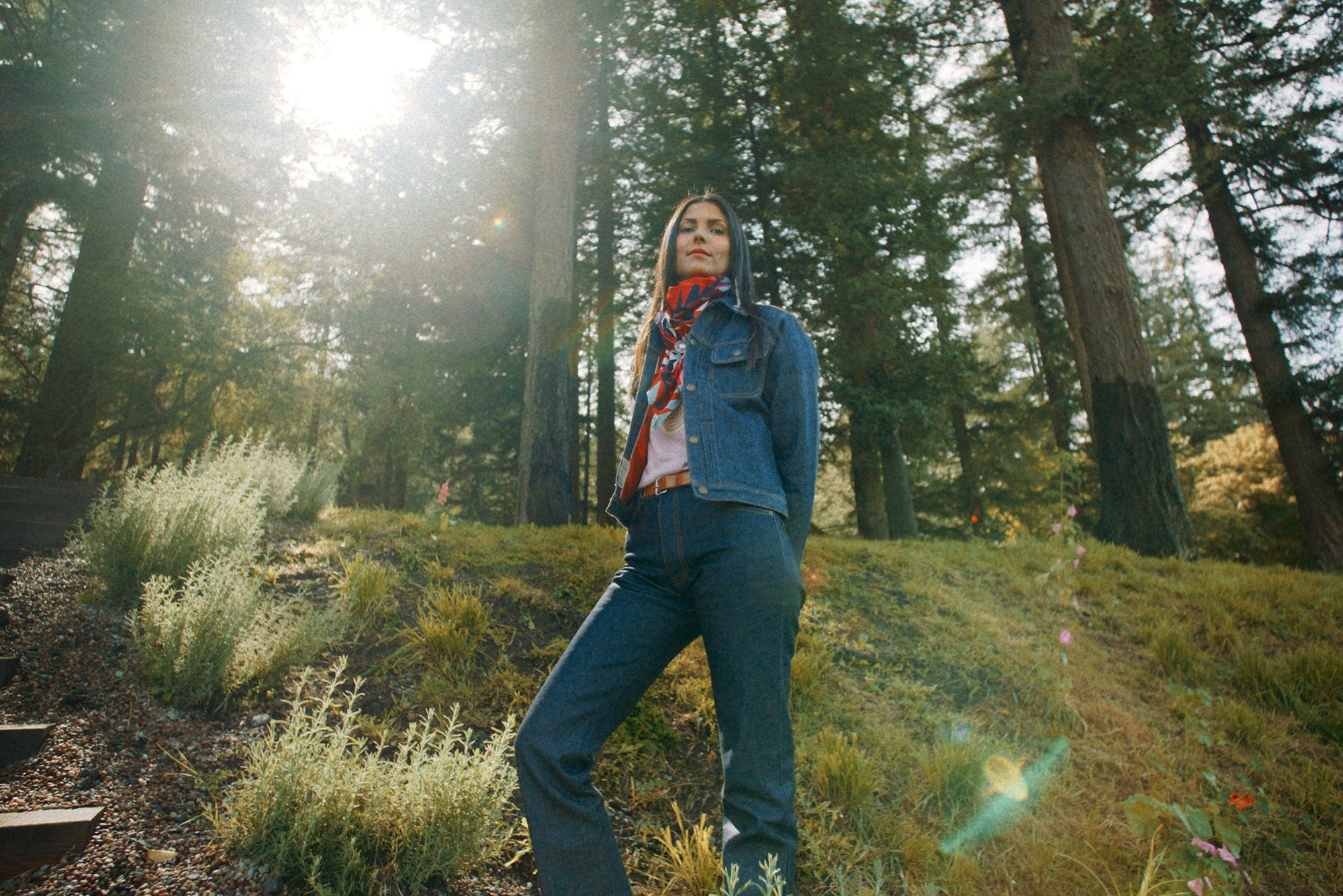 Selvedge denim jeans and coat made in USA on Native American model standing in woods
