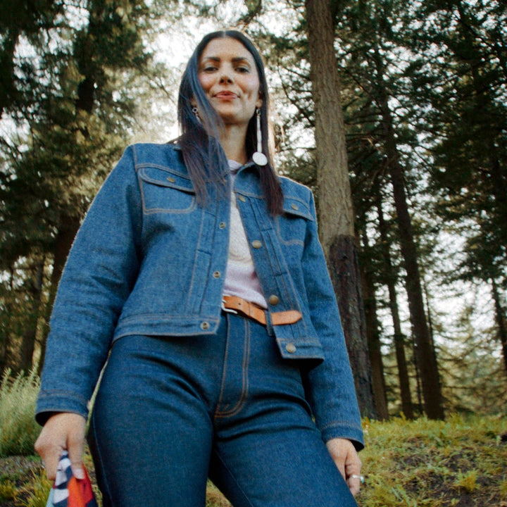 Made in USA denim jacket with colorful lining on Native American model in woods. 
