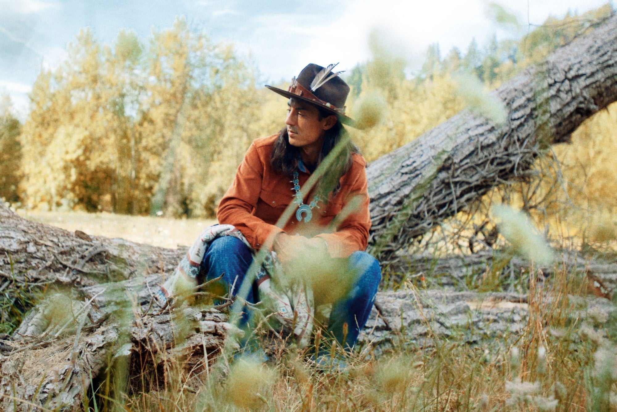 Native American Ginew model wearing made in USA orange corduroy shirt in woods