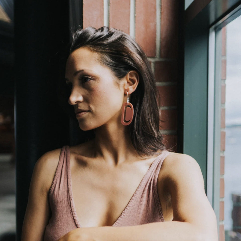 Woman wearing Peach pink Native American made earrings by Copper Canoe Woman 