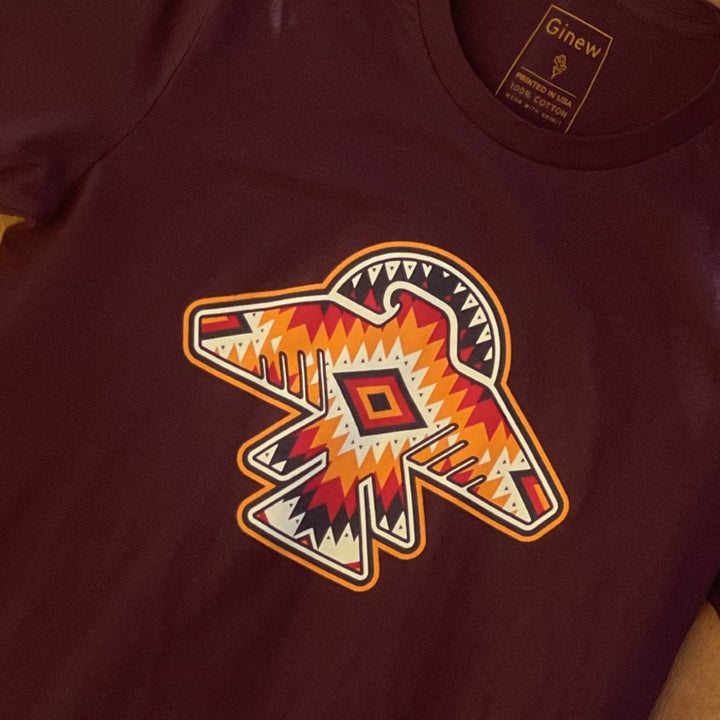 Close up of Ginew's Native American cotton Thunderbird t-shirt in dark maroon purple with orange and yellow t-bird