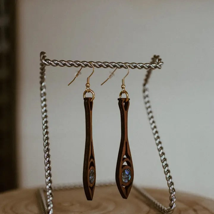 Paddle shaped earrings made of cedar wood and abalone worn and made by Native American women 