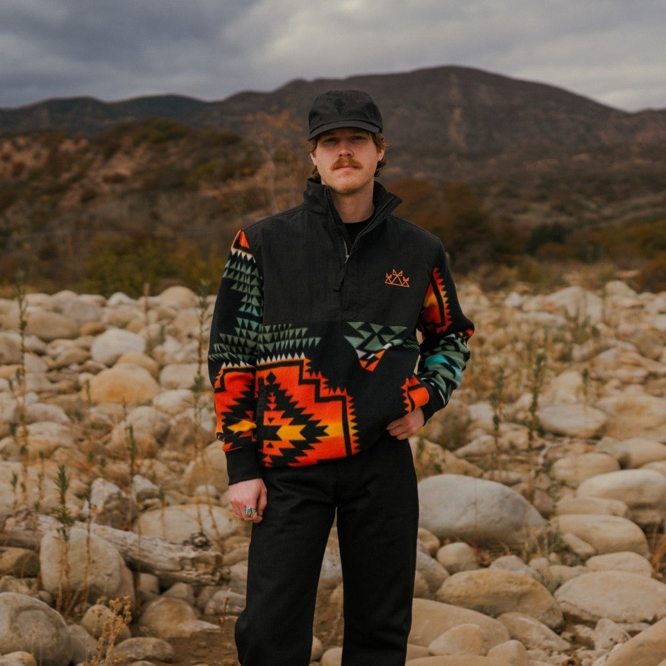 Front of Native Americana popover half zip pullover in fleece and nylon on man in rocky field