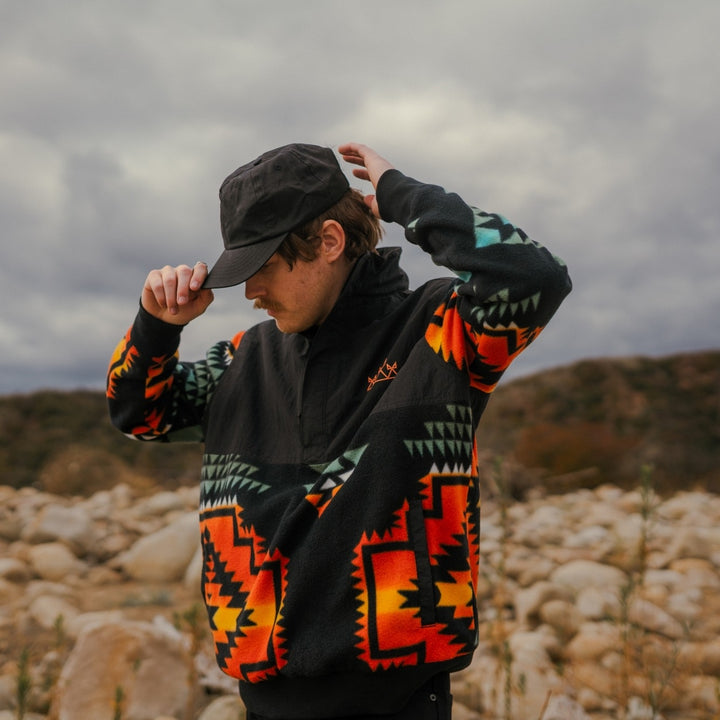 Native Americana popover half zip pullover in fleece and nylon on man in rocky field