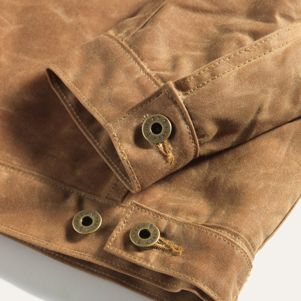 Detail view of sleeve cuff hardware and adjustable button on back hem.