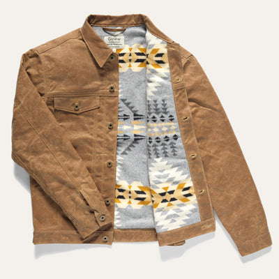 Full view of Wax Rider Coat in Brown with Pendleton lining. Right half of coat lay closed with sleeve over it while the left side is panned open to see the inside lining. Coat on a neutral background.