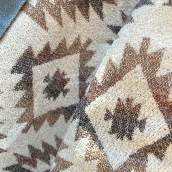 Lining close up of Grey silver charcoal wax canvas rider coat lined with  Native American design in  brown and cream wool interior made by Indigenous owned Ginew