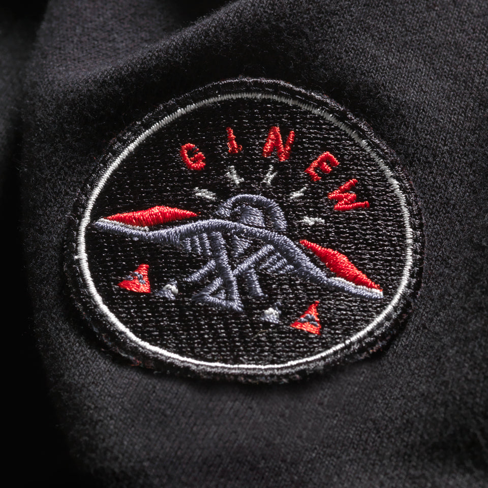 Black red and blue Thunderbird patch with word Ginew on Black rugby shirt with white collar 